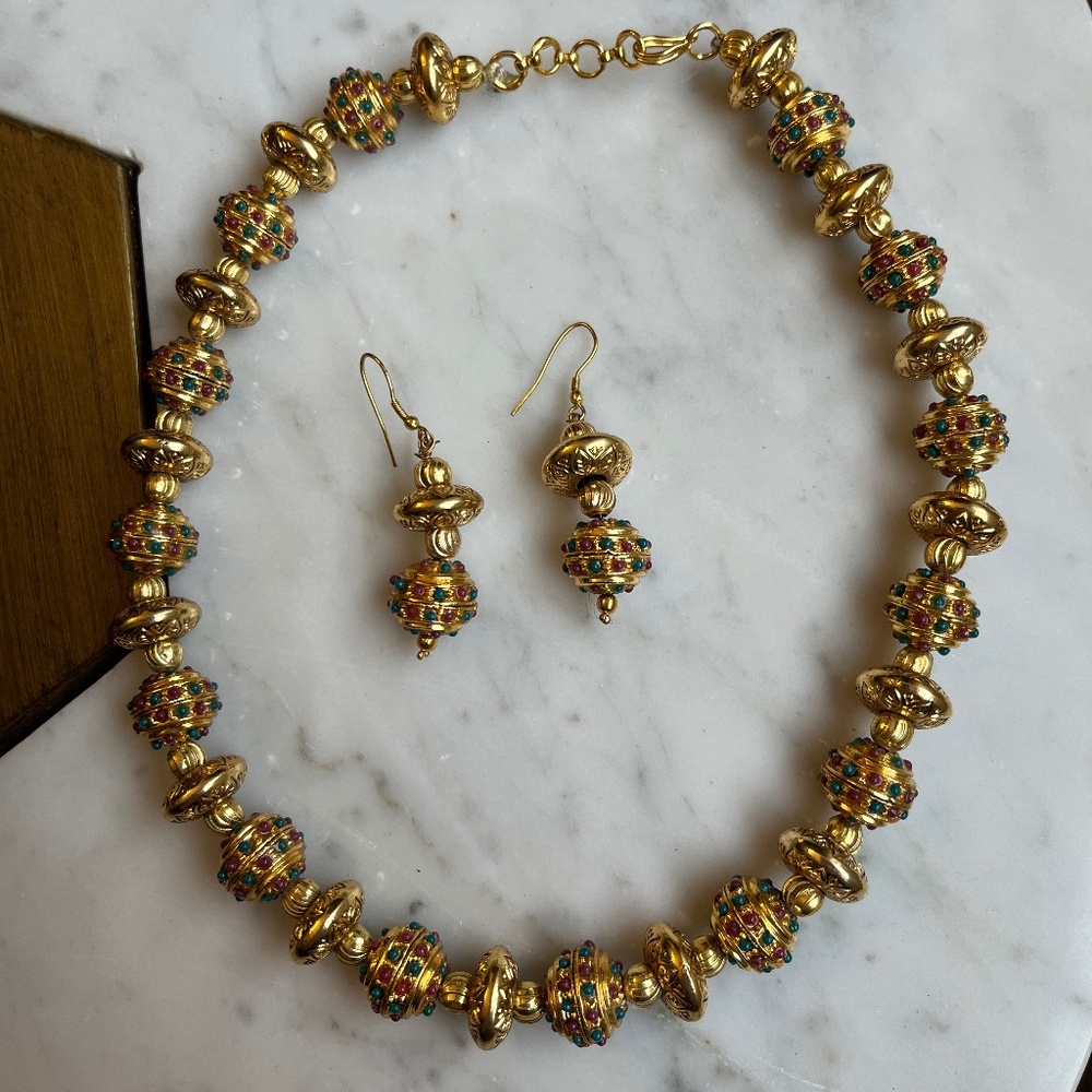 Bright gold artisnal necklace and earrings set, with green & red accents.